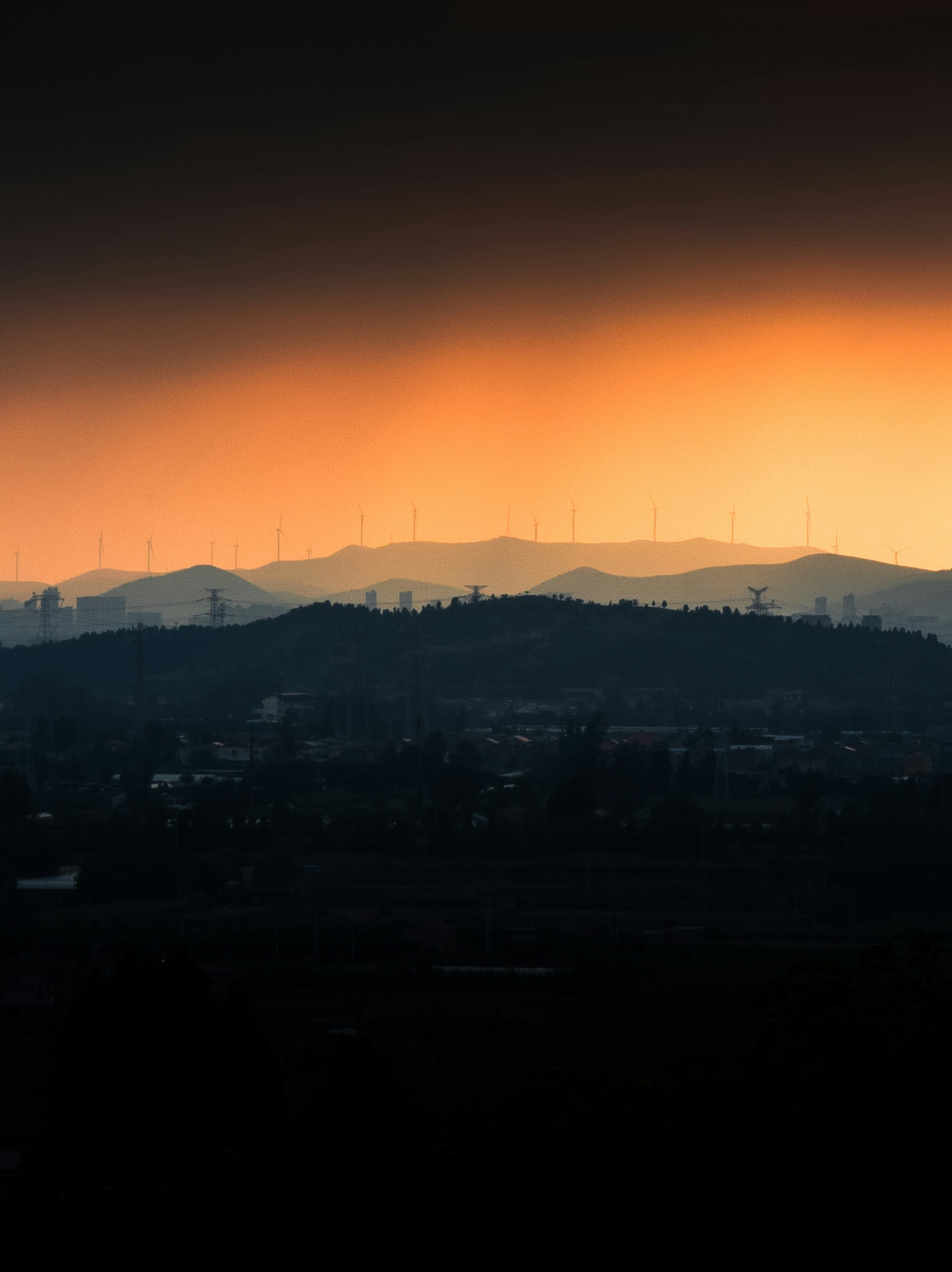 Silhouetted hills and wind turbines at sunset