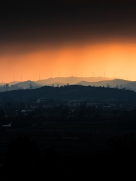 Silhouetted hills and wind turbines at sunset
