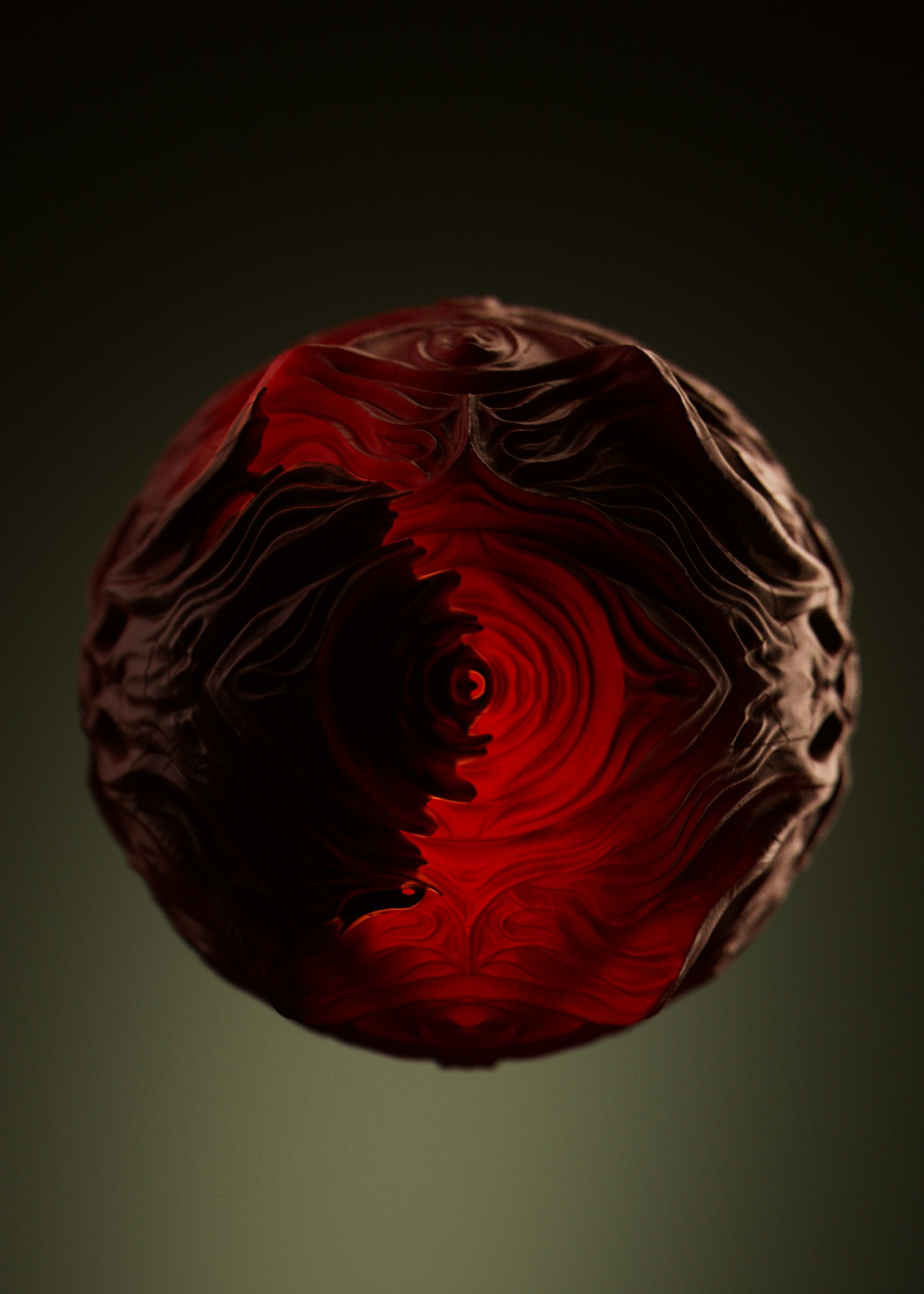 A dark, intricately carved sphere with glowing red interior