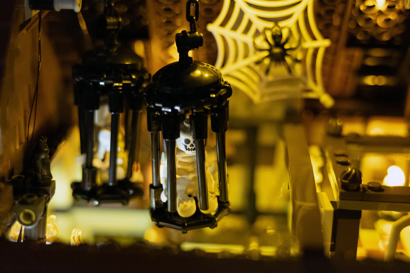 Black Halloween lanterns glowing in front of a spiderweb decoration