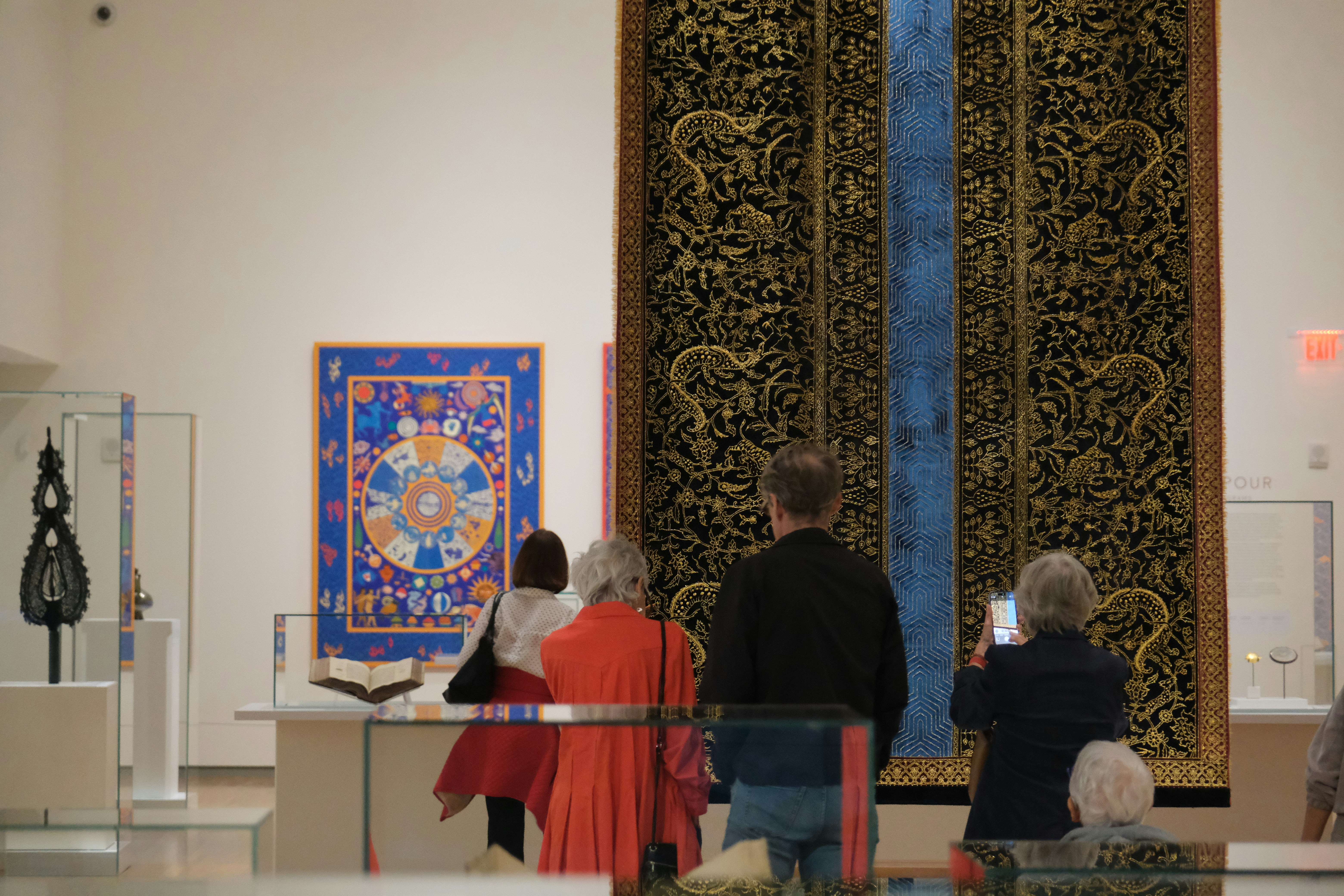People observing artwork in a museum gallery