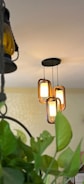 Modern pendant lights with wooden frames hang indoors.