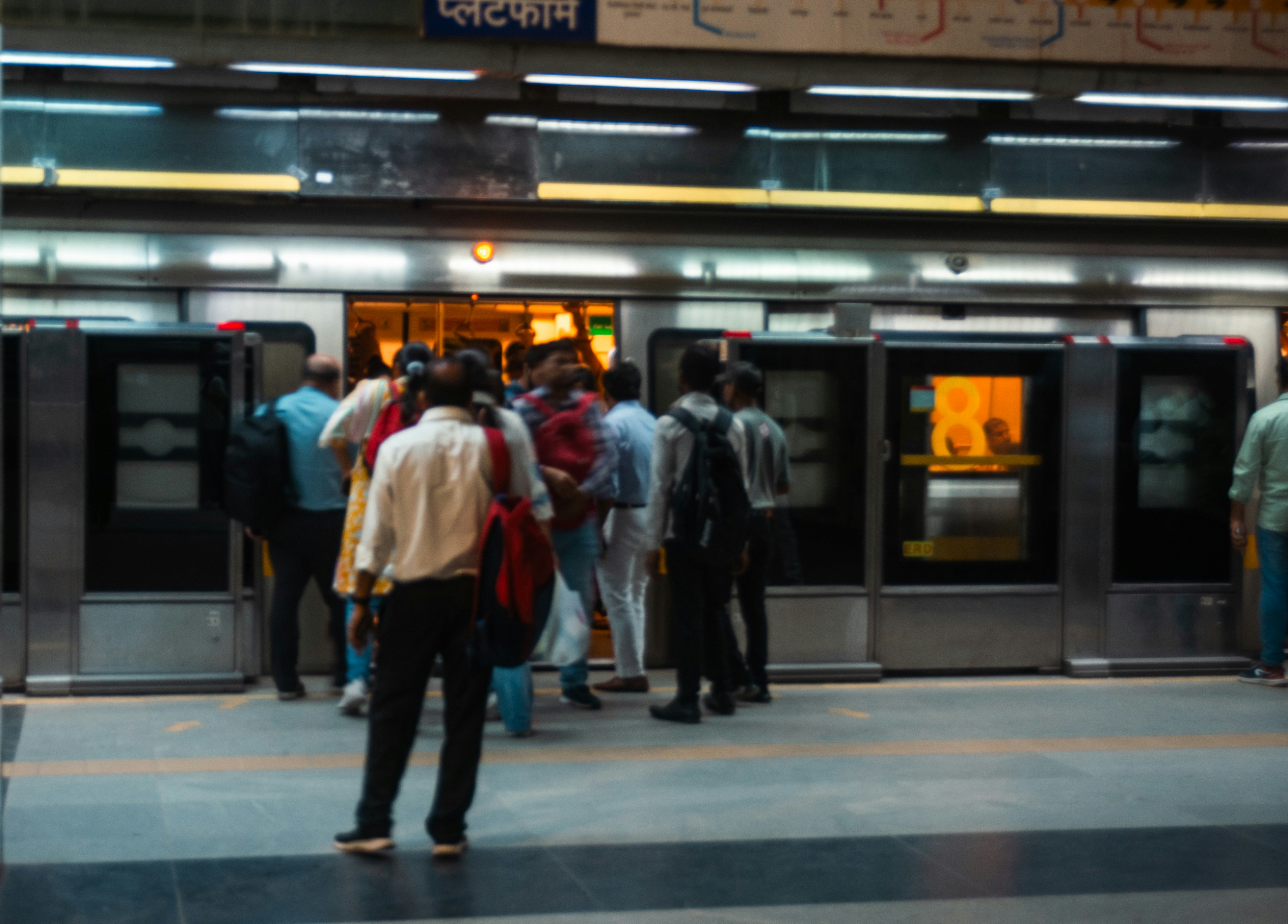 People boarding a train at a metro station in Delhi