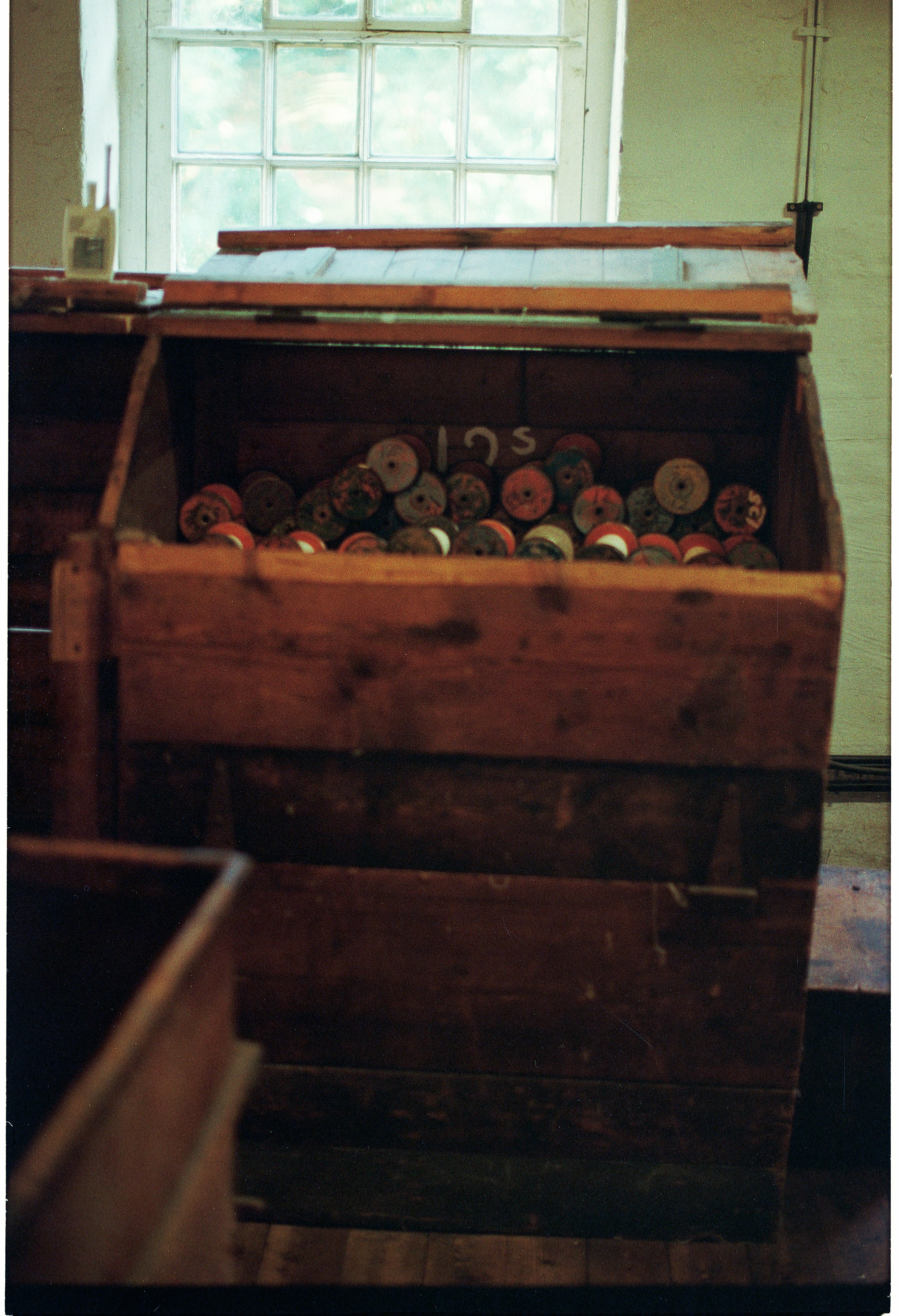 Wooden bin filled with spools of thread