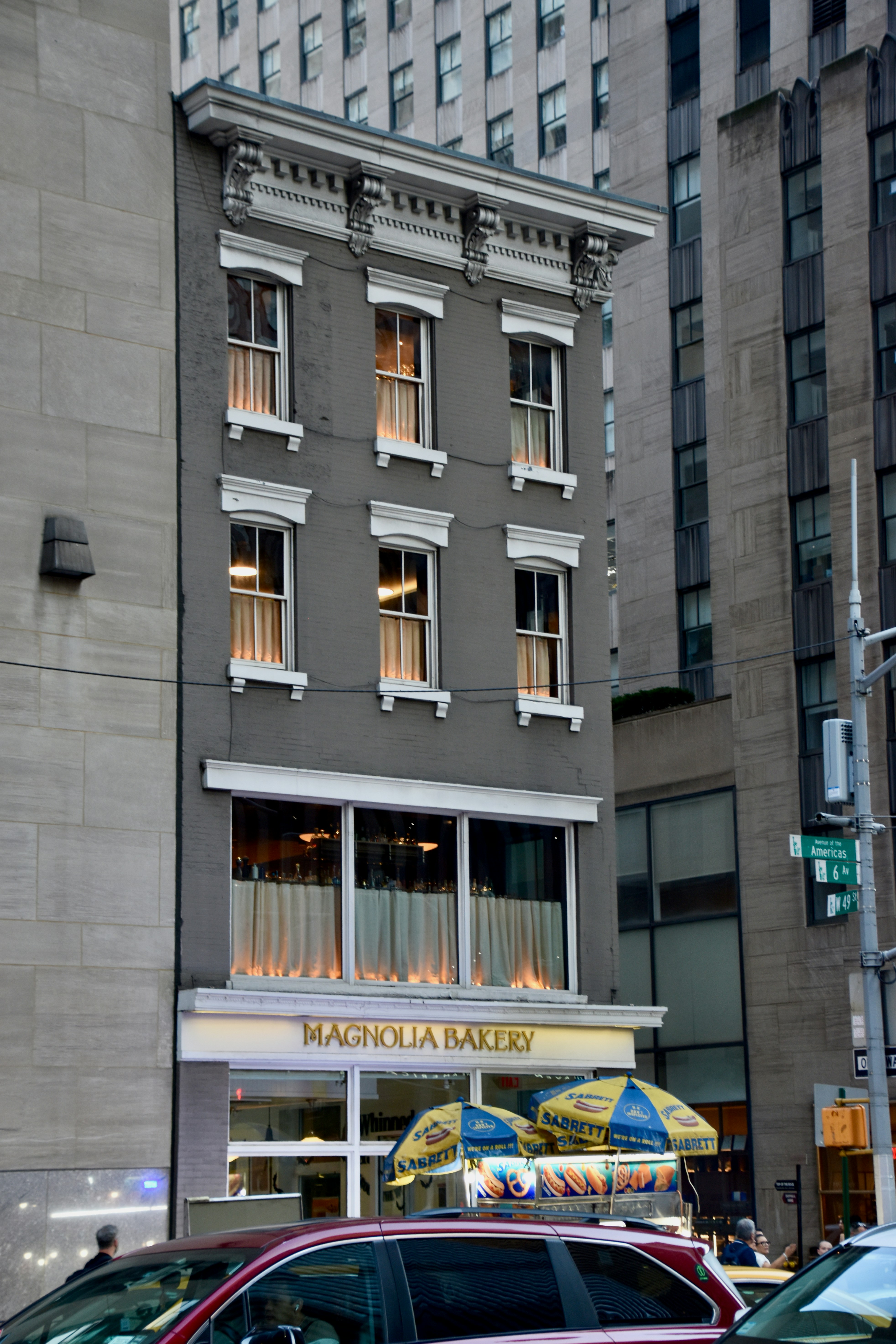 Magnolia bakery storefront between tall city buildings