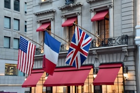 American, french, and british flags on building