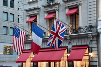 American, french, and british flags on building