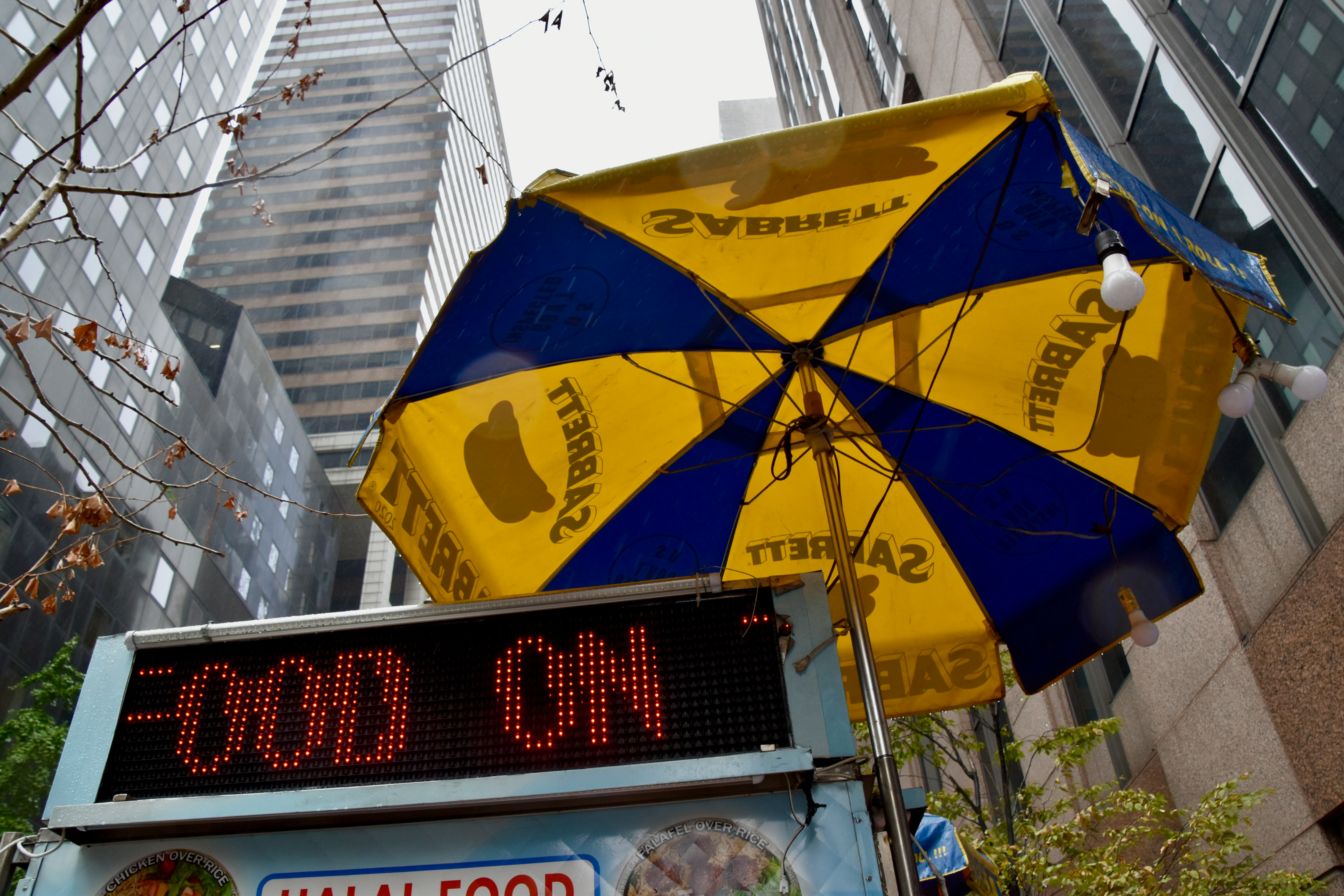 Yellow and blue umbrella over a food cart.