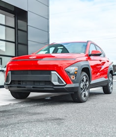 A red compact suv parked outside a modern building.