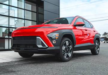 A red suv parked outside a modern building.