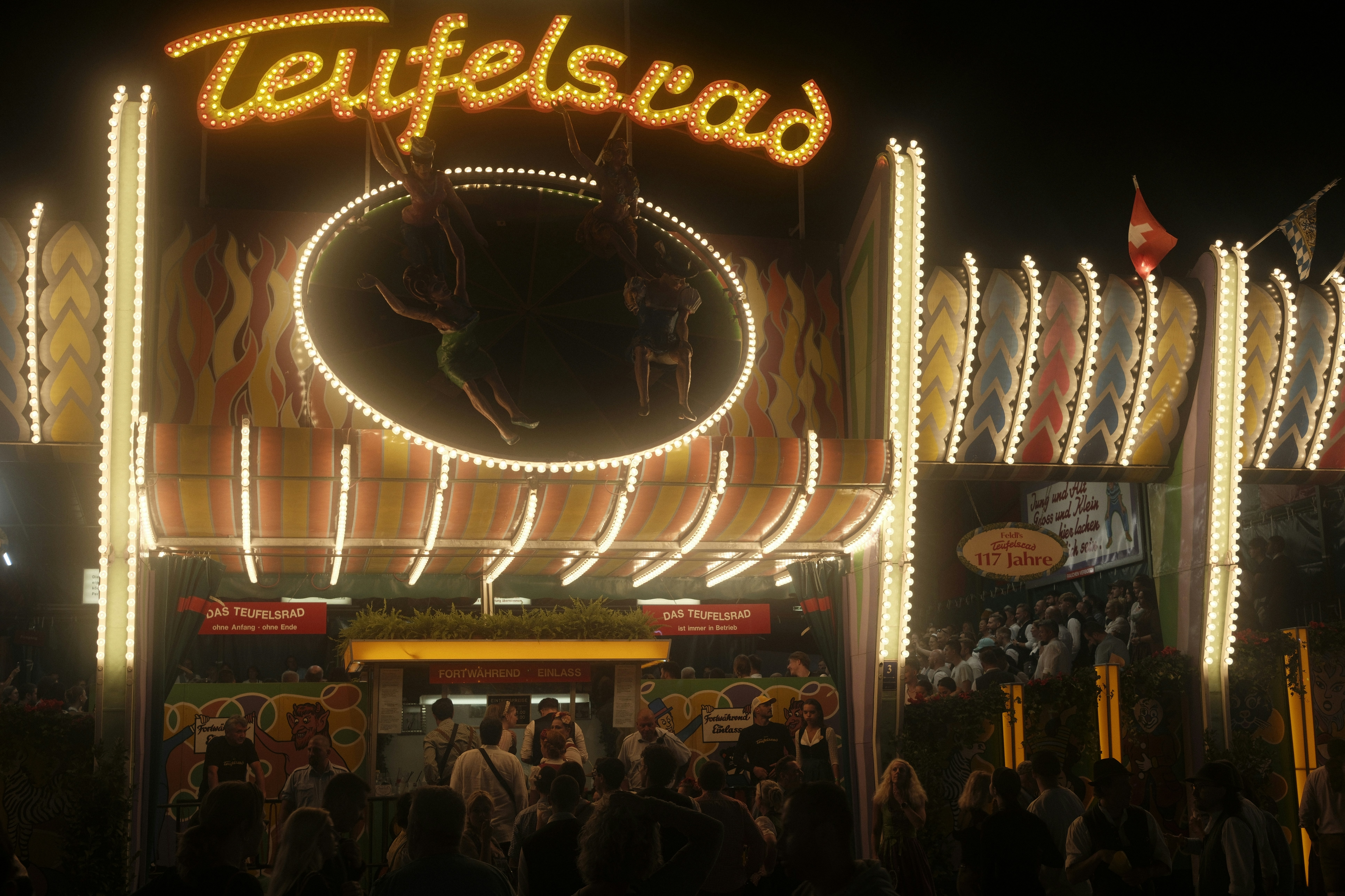 A funfair ride entrance glowing against the night on the Theresienwiese festival grounds in Munich