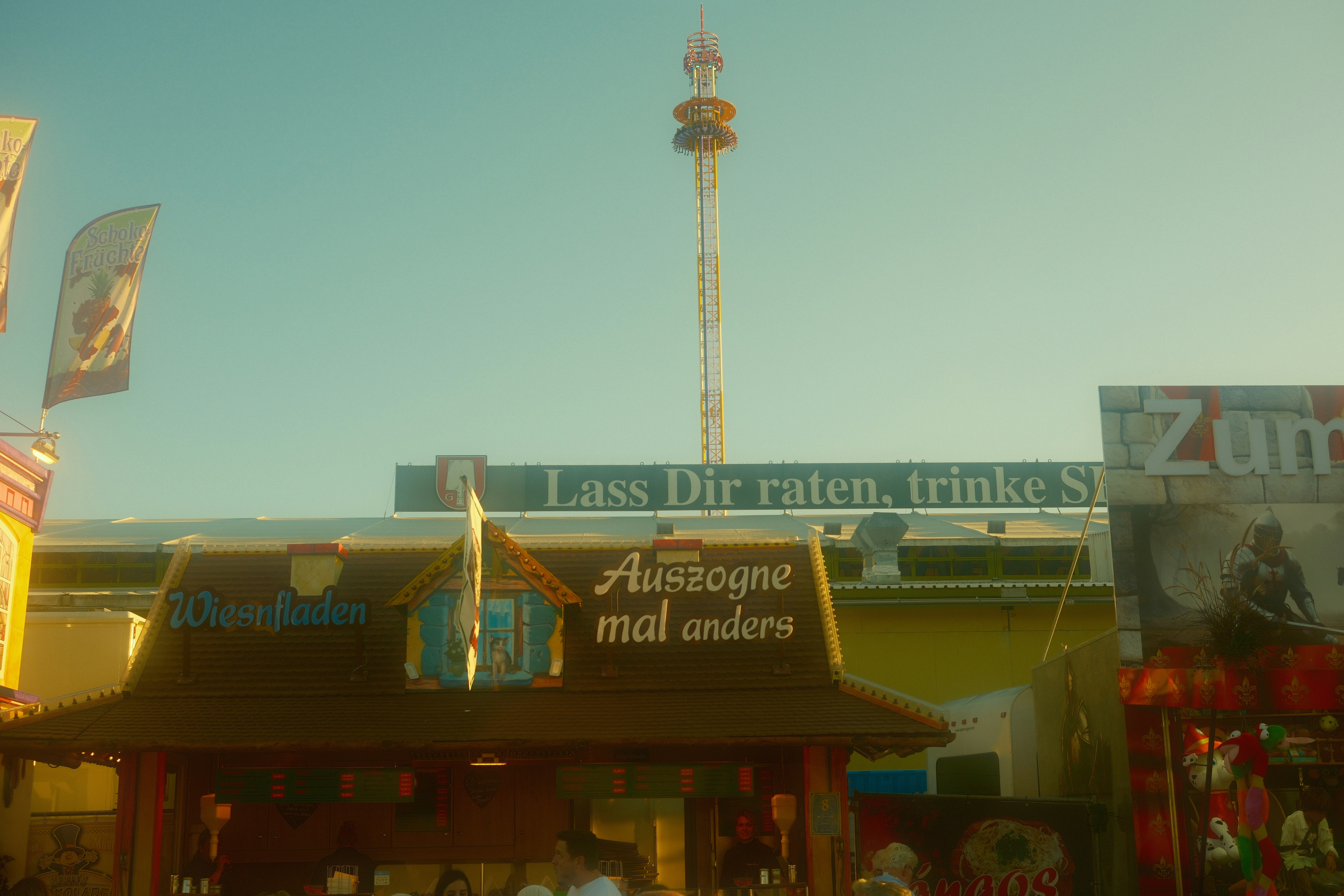 The Oktoberfest funfair tower and tent rows rising above the stalls on the Theresienwiese in Munich