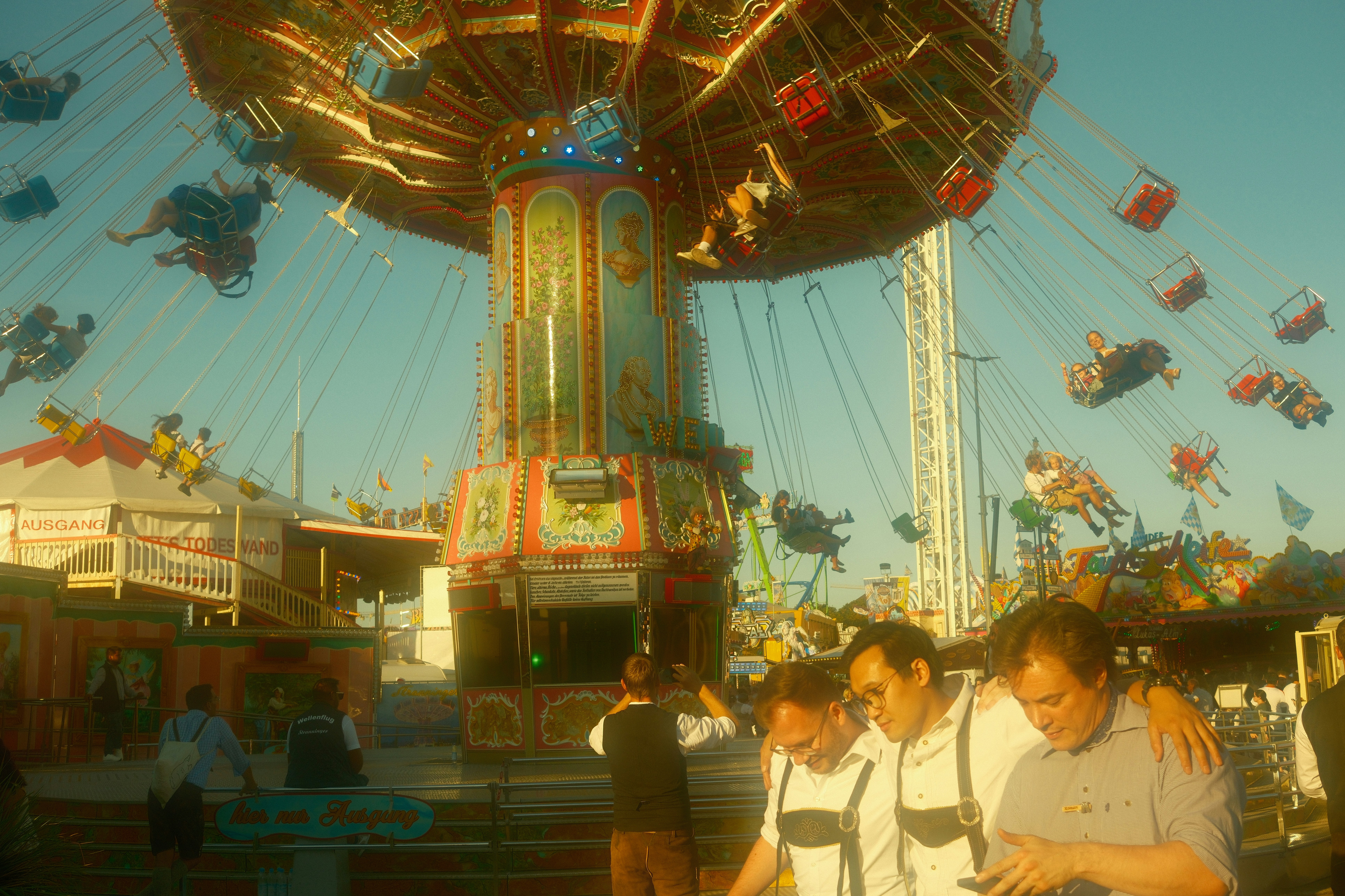People enjoying a carnival swing ride on a sunny day.