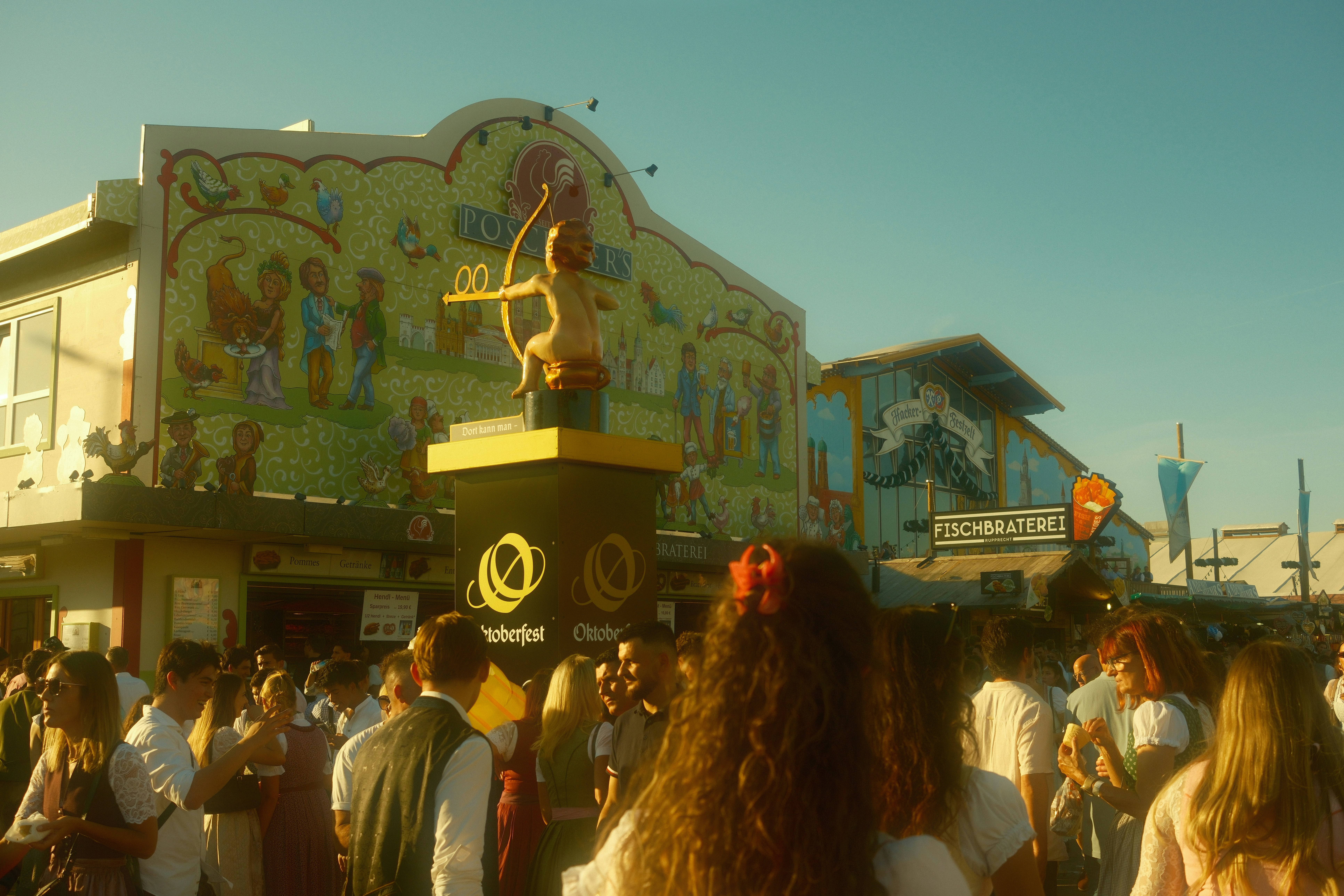 Crowd gathered near a mural and statue