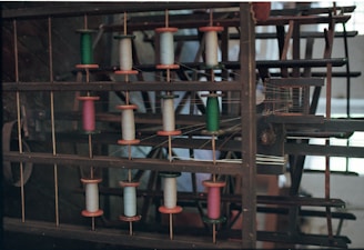 Spools of colorful thread on a wooden rack