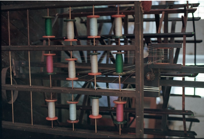 Spools of colorful thread on a wooden rack