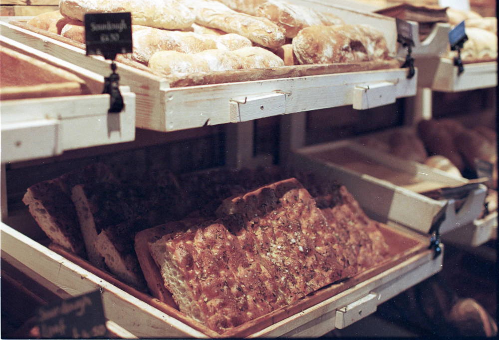 Fresh bread displayed on wooden bakery shelves
