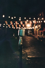Vintage microphone on stand with string lights