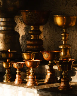 Several ornate brass oil lamps with lit flames.