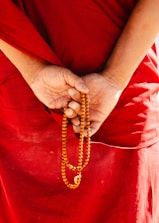 Monk holding prayer beads behind back