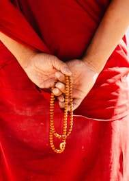 Monk holding prayer beads behind back
