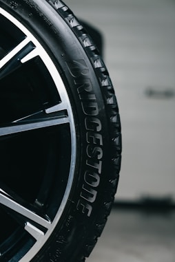 Close-up of a wet bridgestone tire on a car wheel.