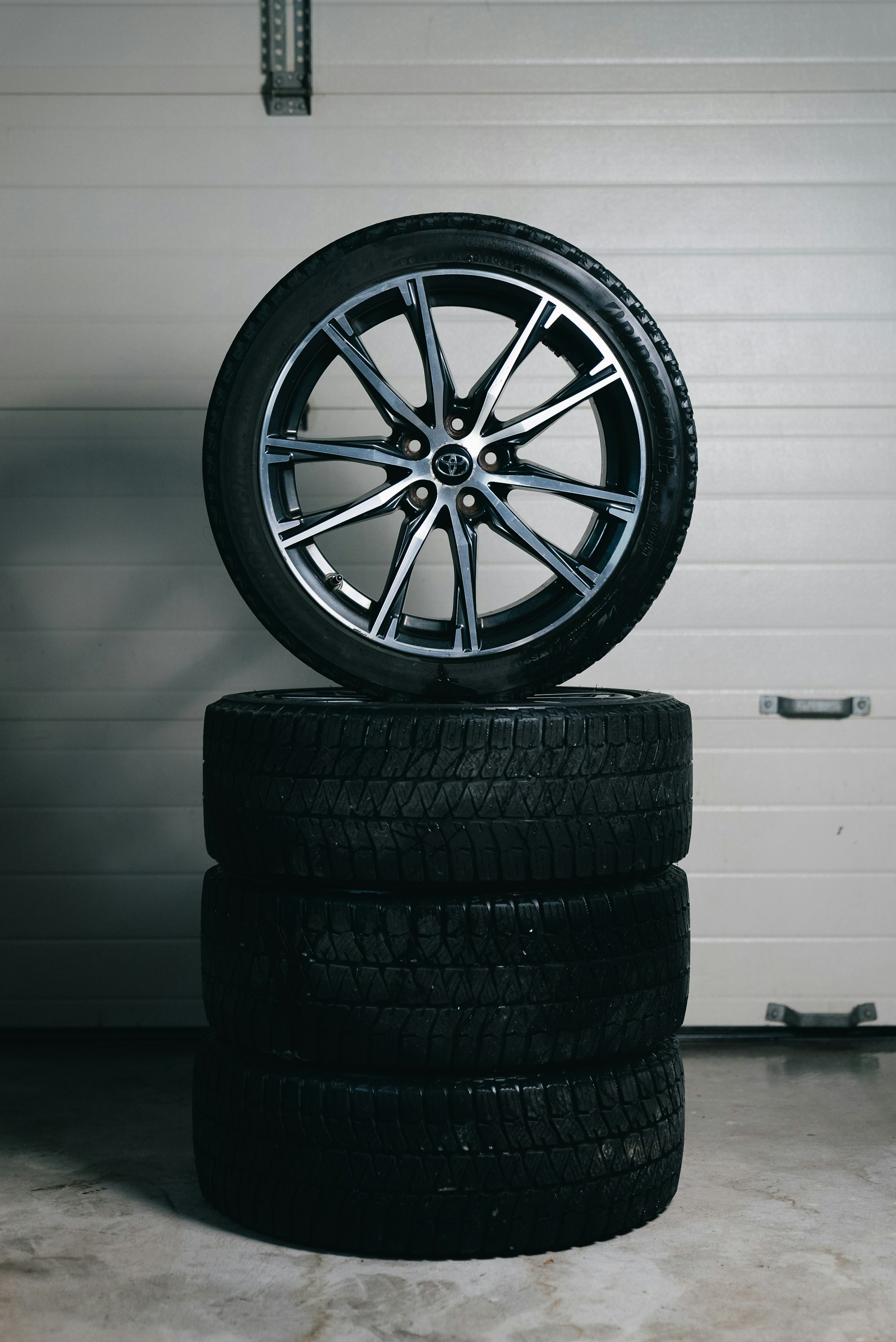 Stack of car tires with one alloy wheel on top