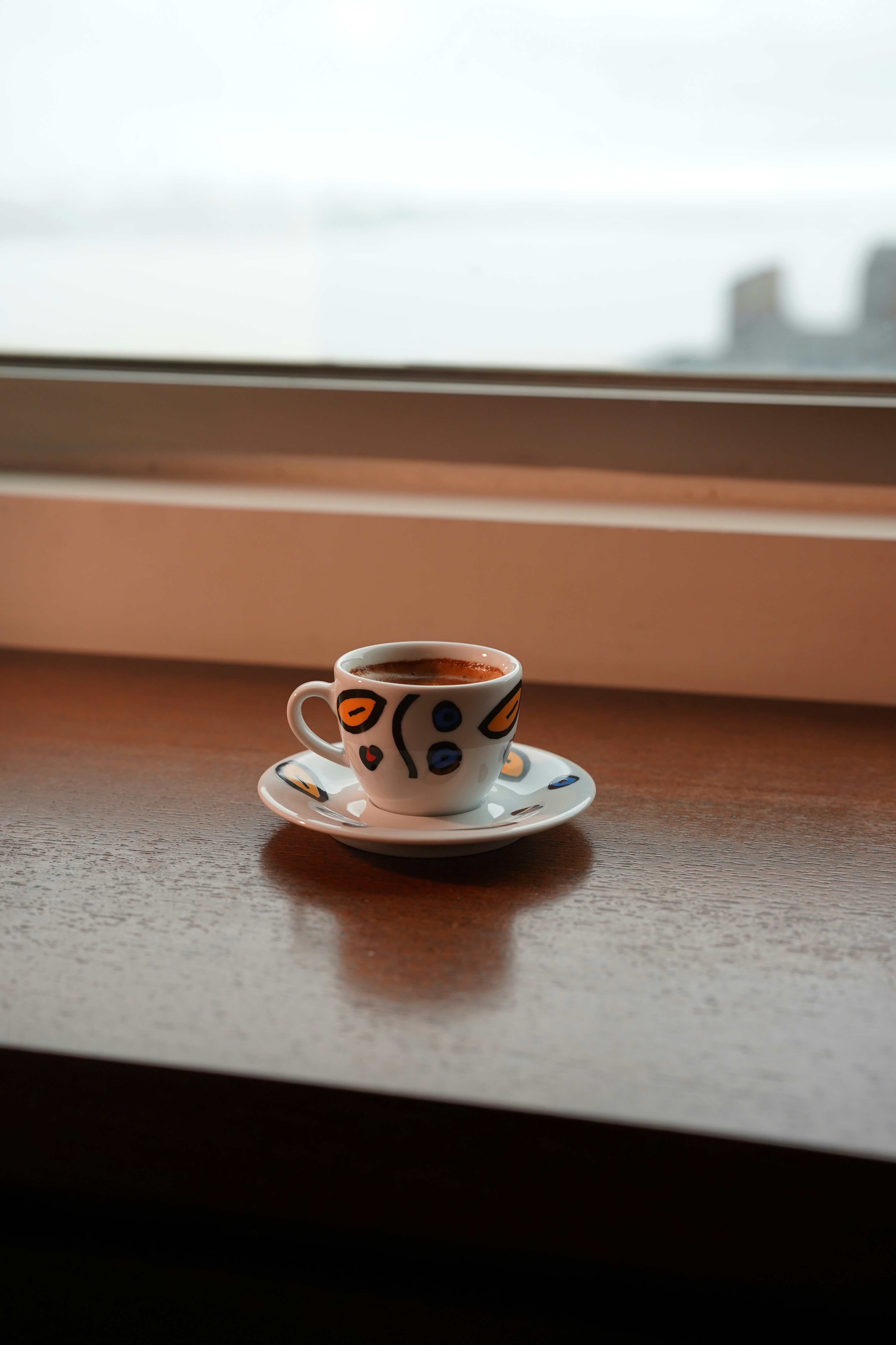 A small cup of coffee on a saucer.