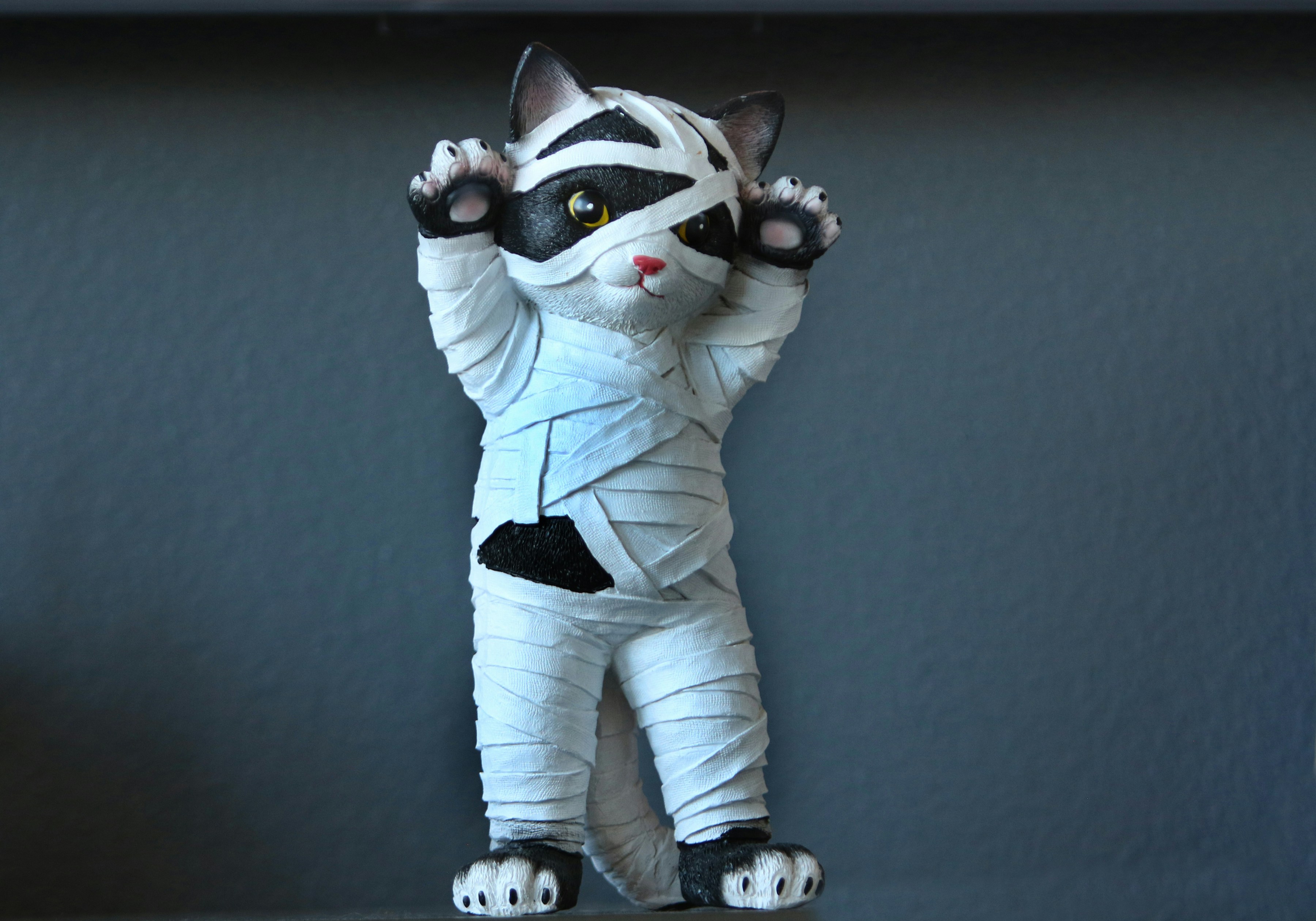A cat figurine wrapped in bandages like a mummy.