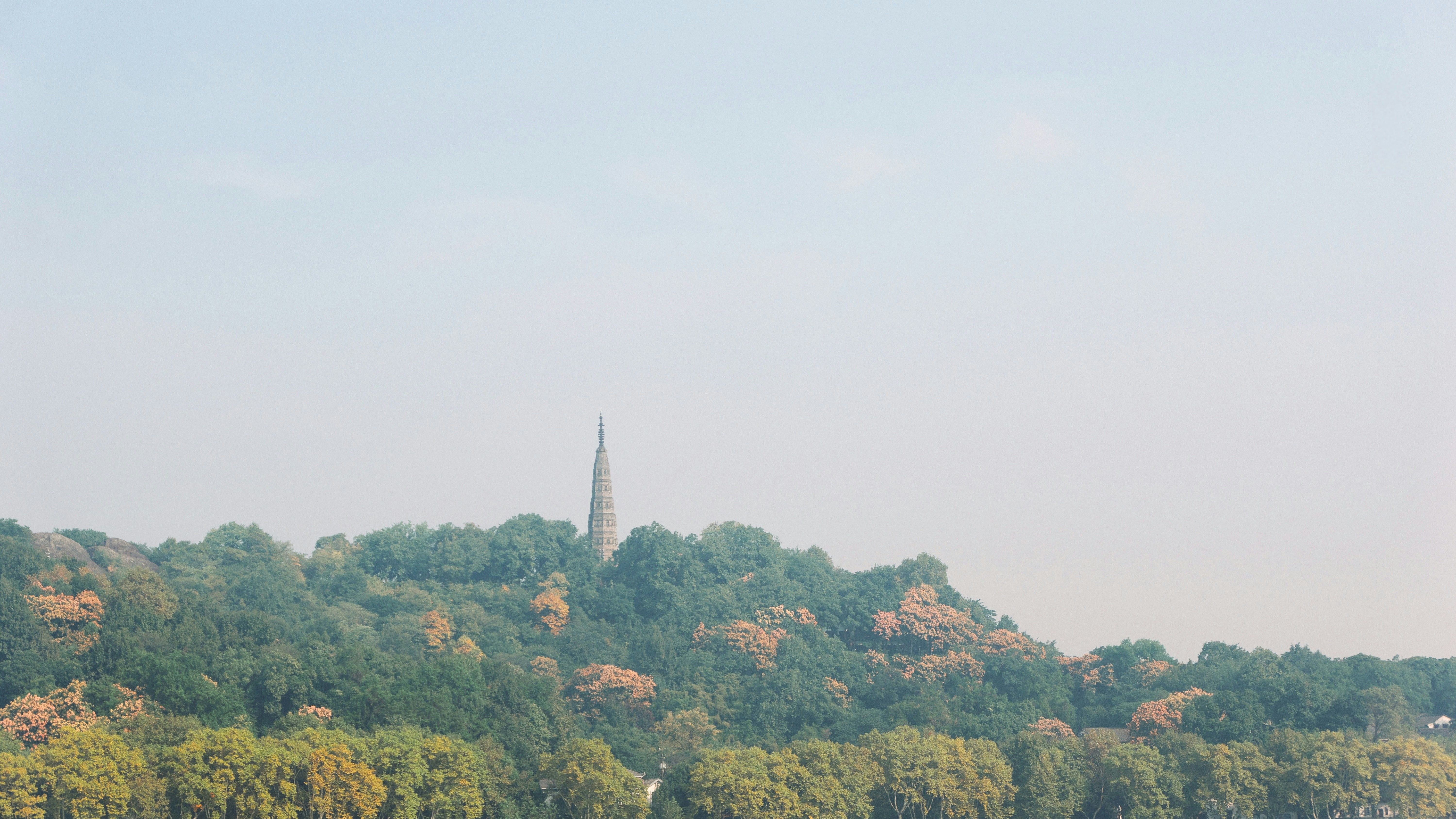 Hilltop pagoda surrounded by lush green trees