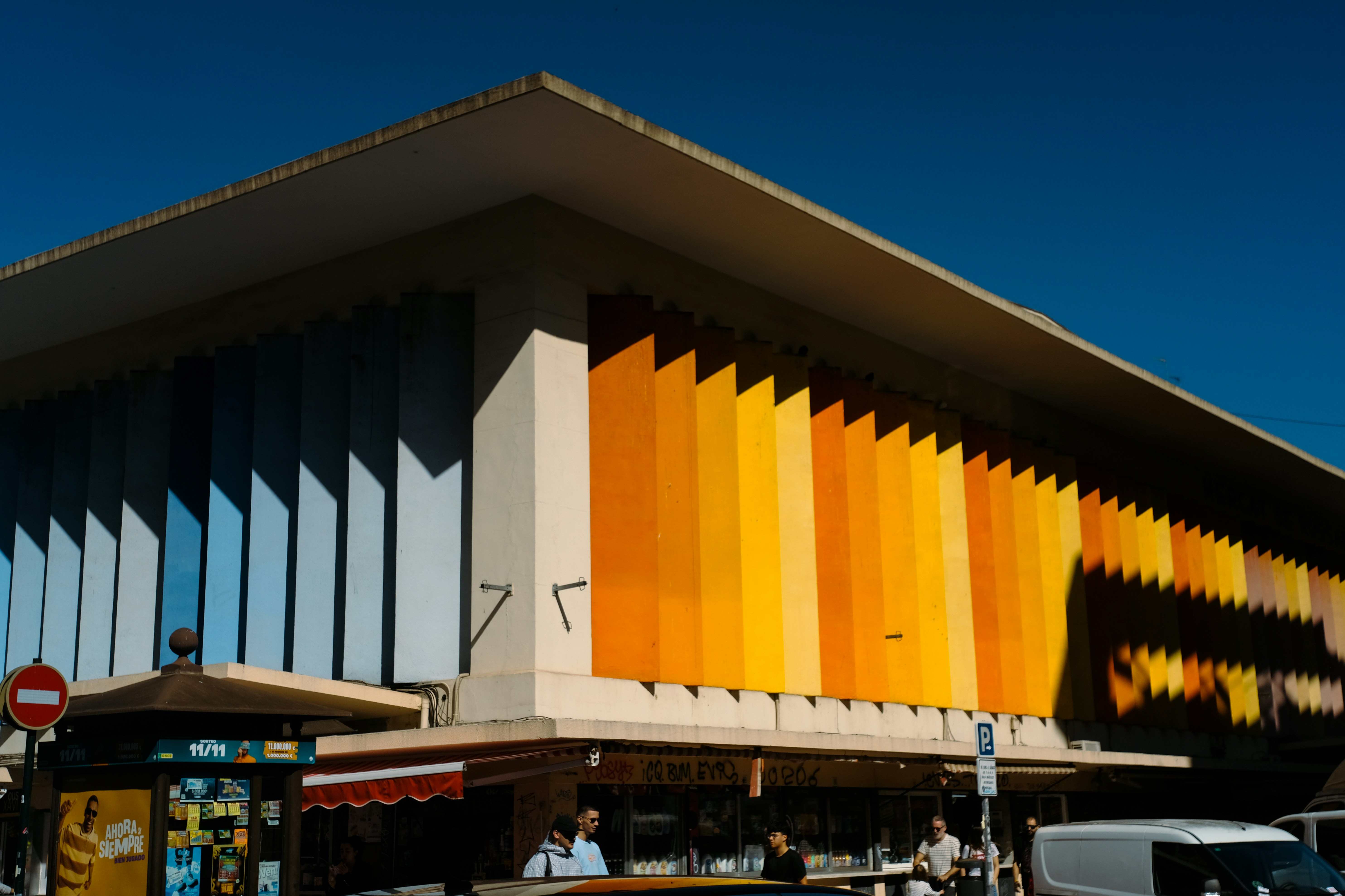 Modernes Gebäude mit bunt gestreifter Fassade unter blauem Himmel