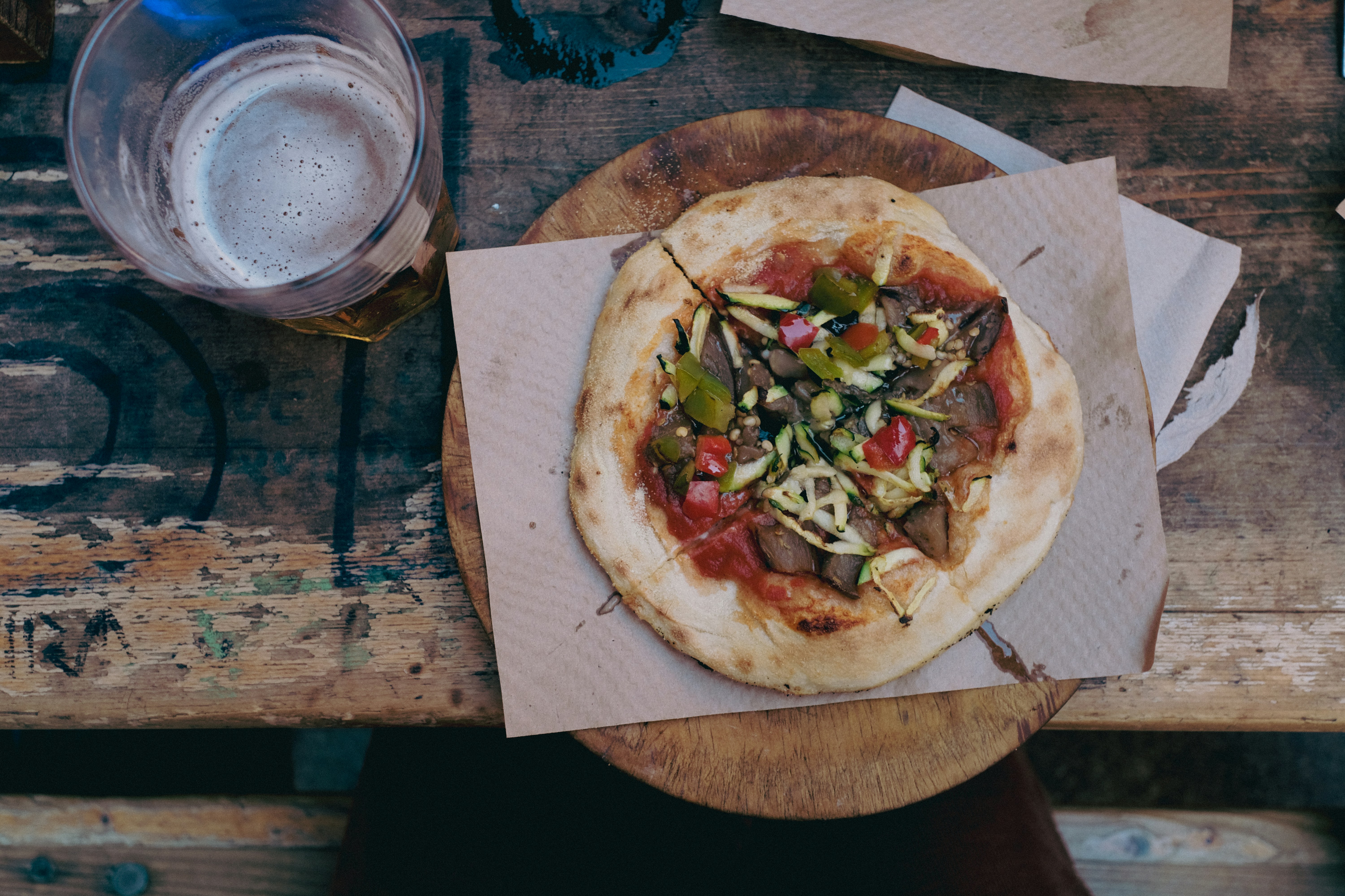 Eine leckere Pizza mit frischen Belägen und einem Bier.
