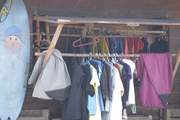 Surfboard and clothes hanging on a rack outdoors rack