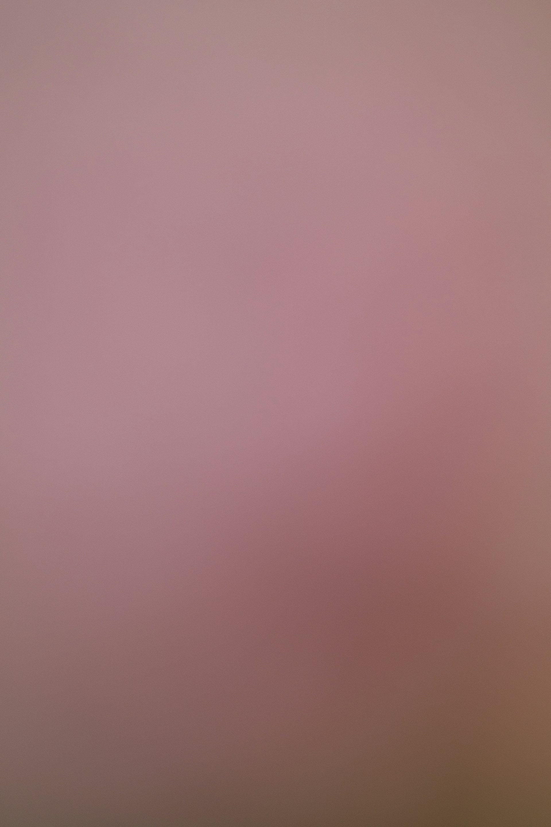 A soft pink and brown gradient background