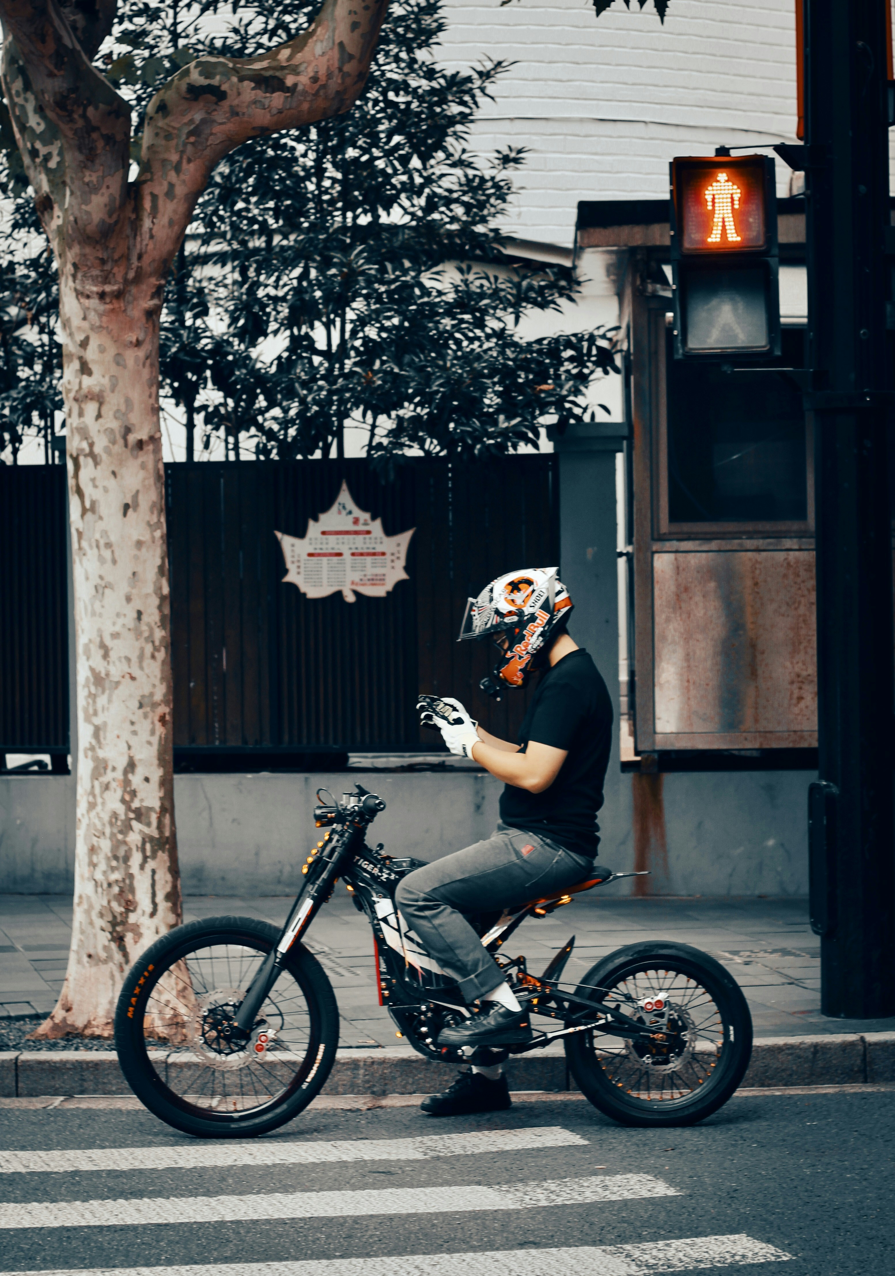 Man in helmet on electric motorcycle at crosswalk