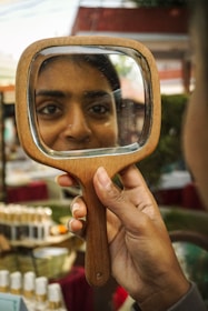 Woman looking at her reflection in a handheld mirror
