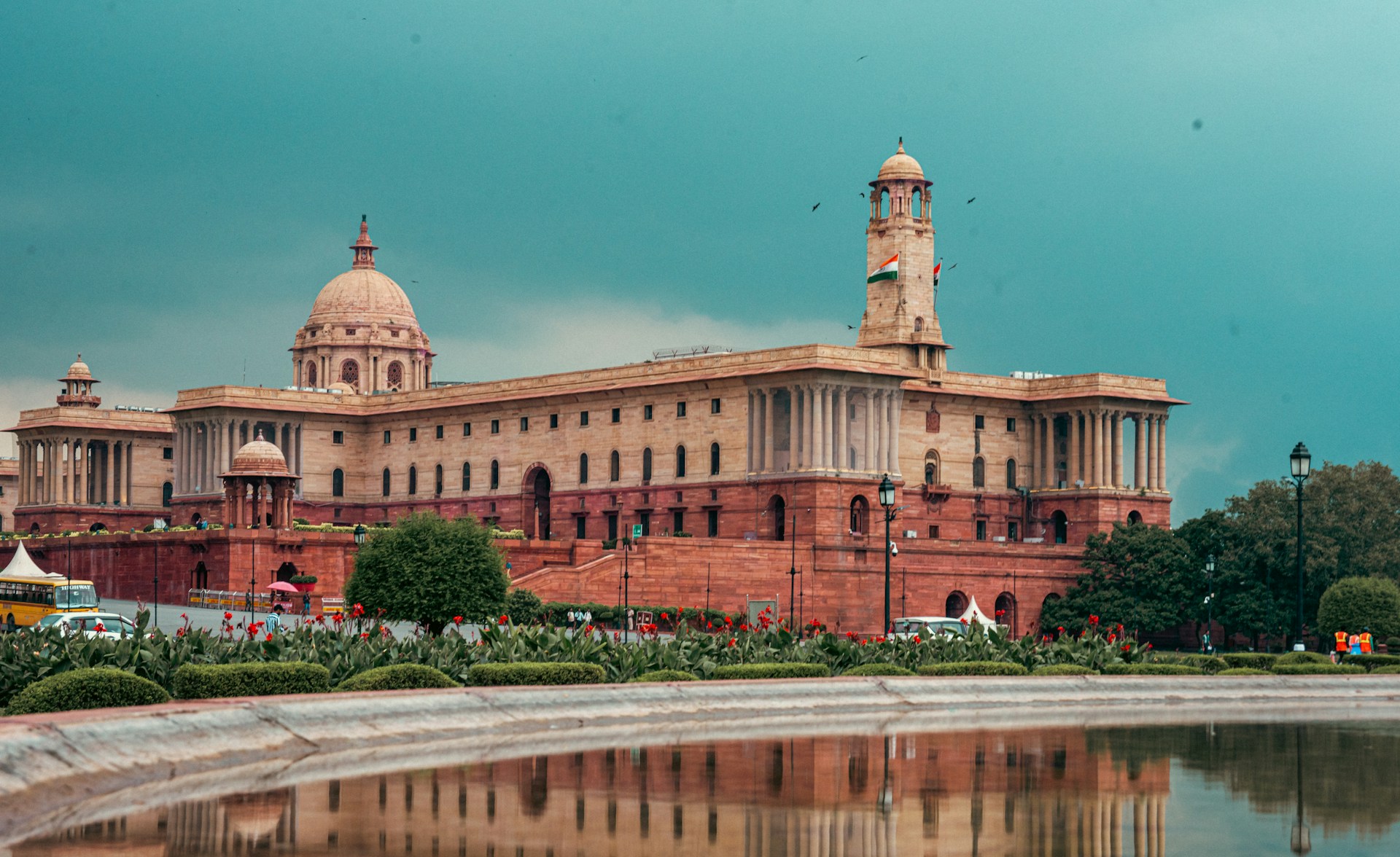 Grand historic building with dome and tower reflected in water.