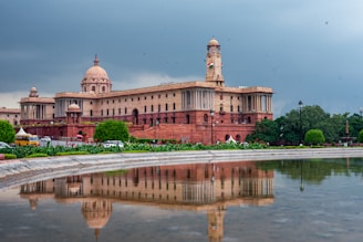 Grand building reflected in a calm pool of water.