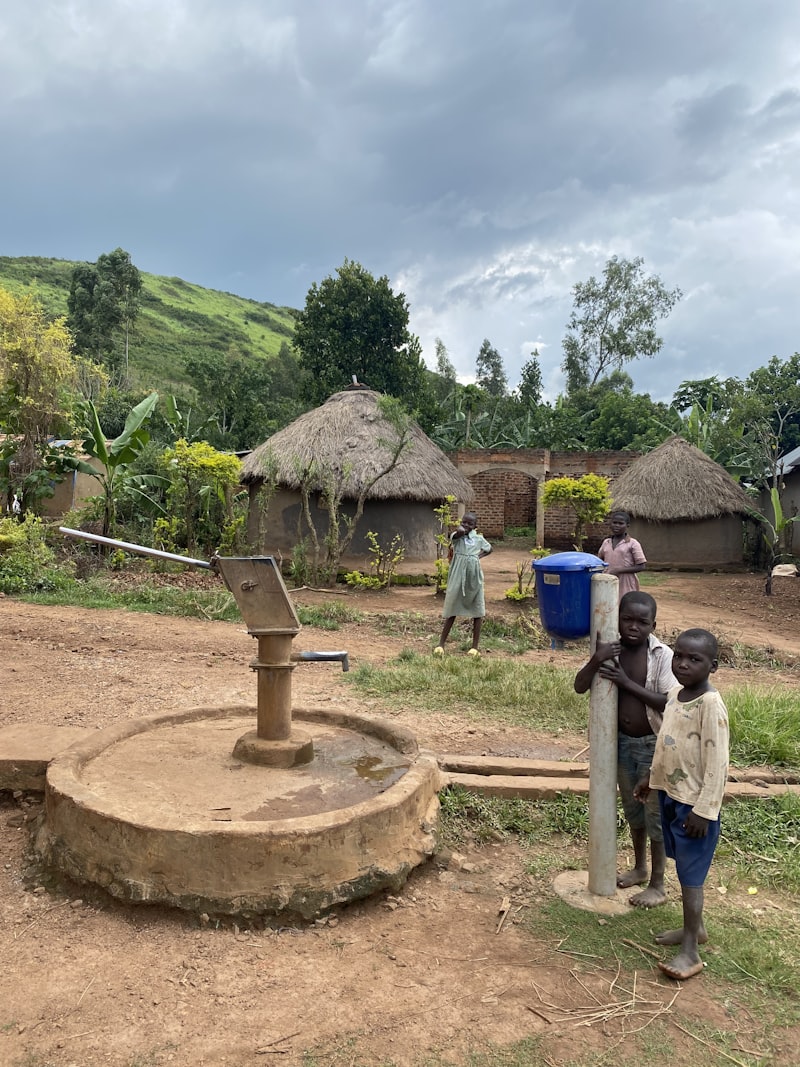 Children stand by a water pump in a village