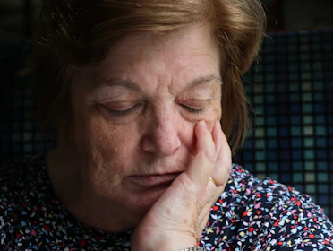 Elderly woman with hand on her cheek