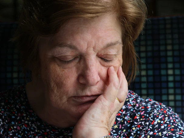 Elderly woman with hand on her cheek
