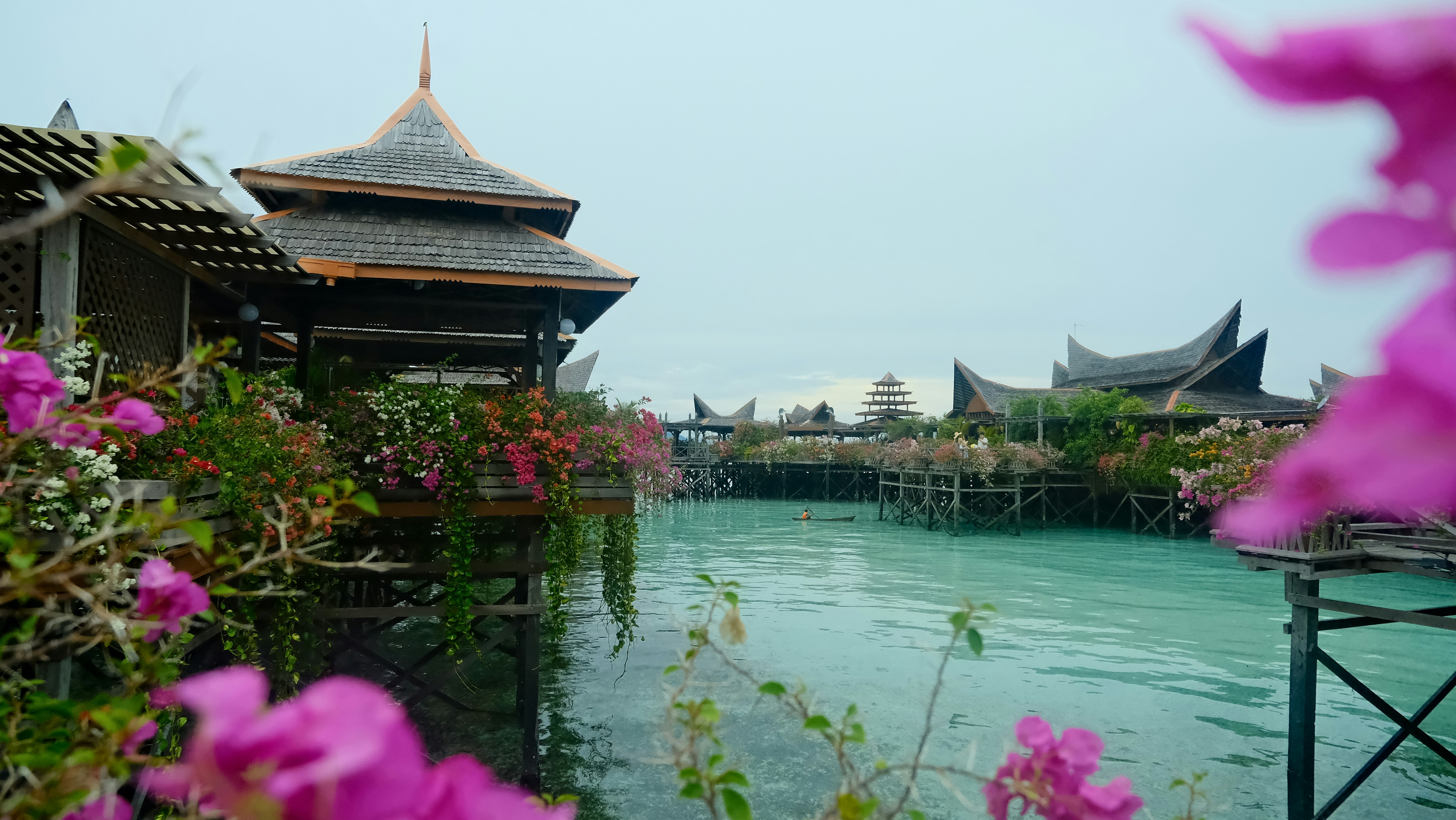Floating village with turquoise water and flowers.