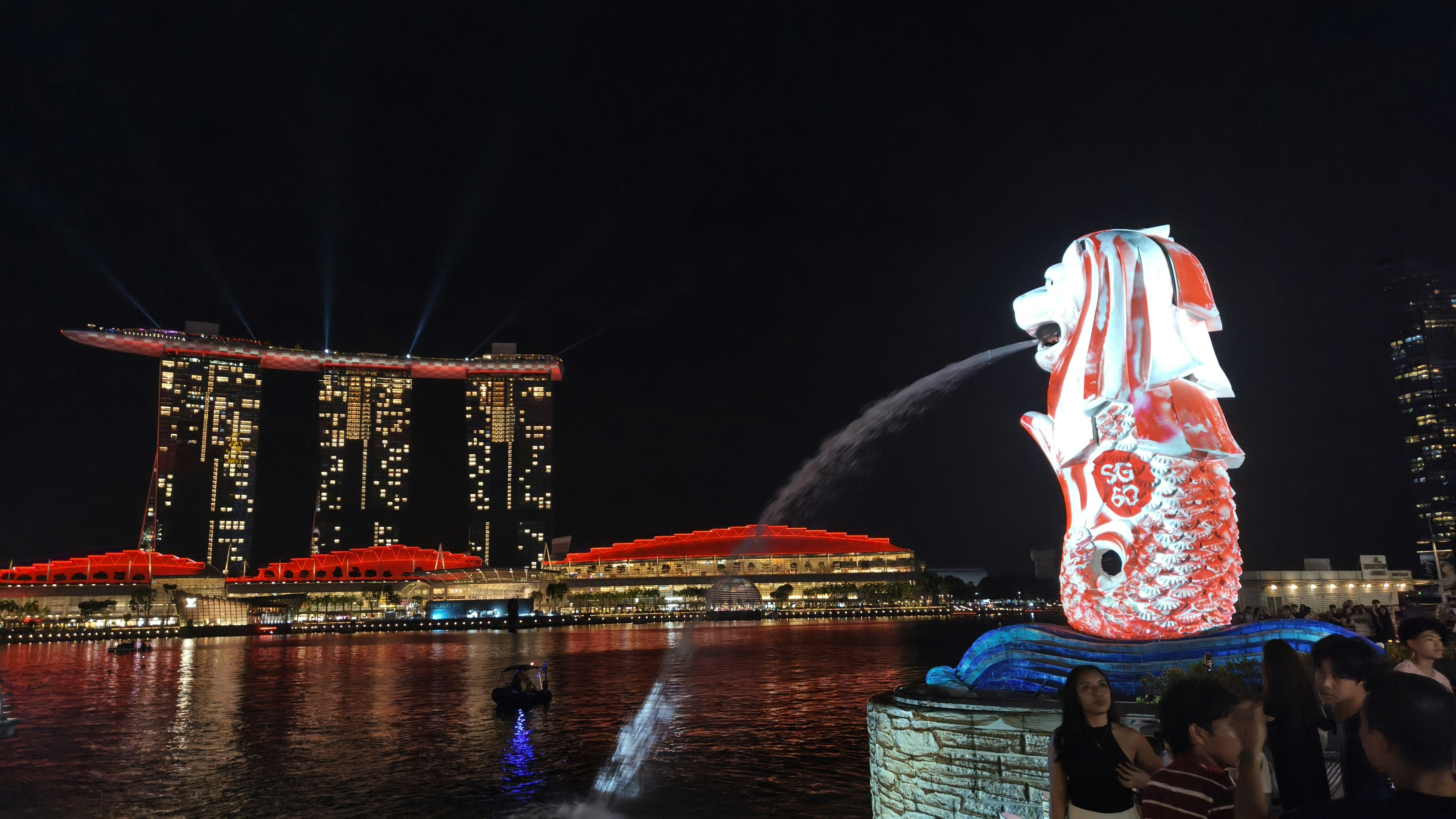 Merlion statue spewing water with marina bay sands at night