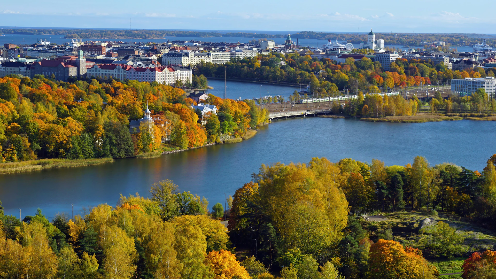 Autumn cityscape with river and colorful trees