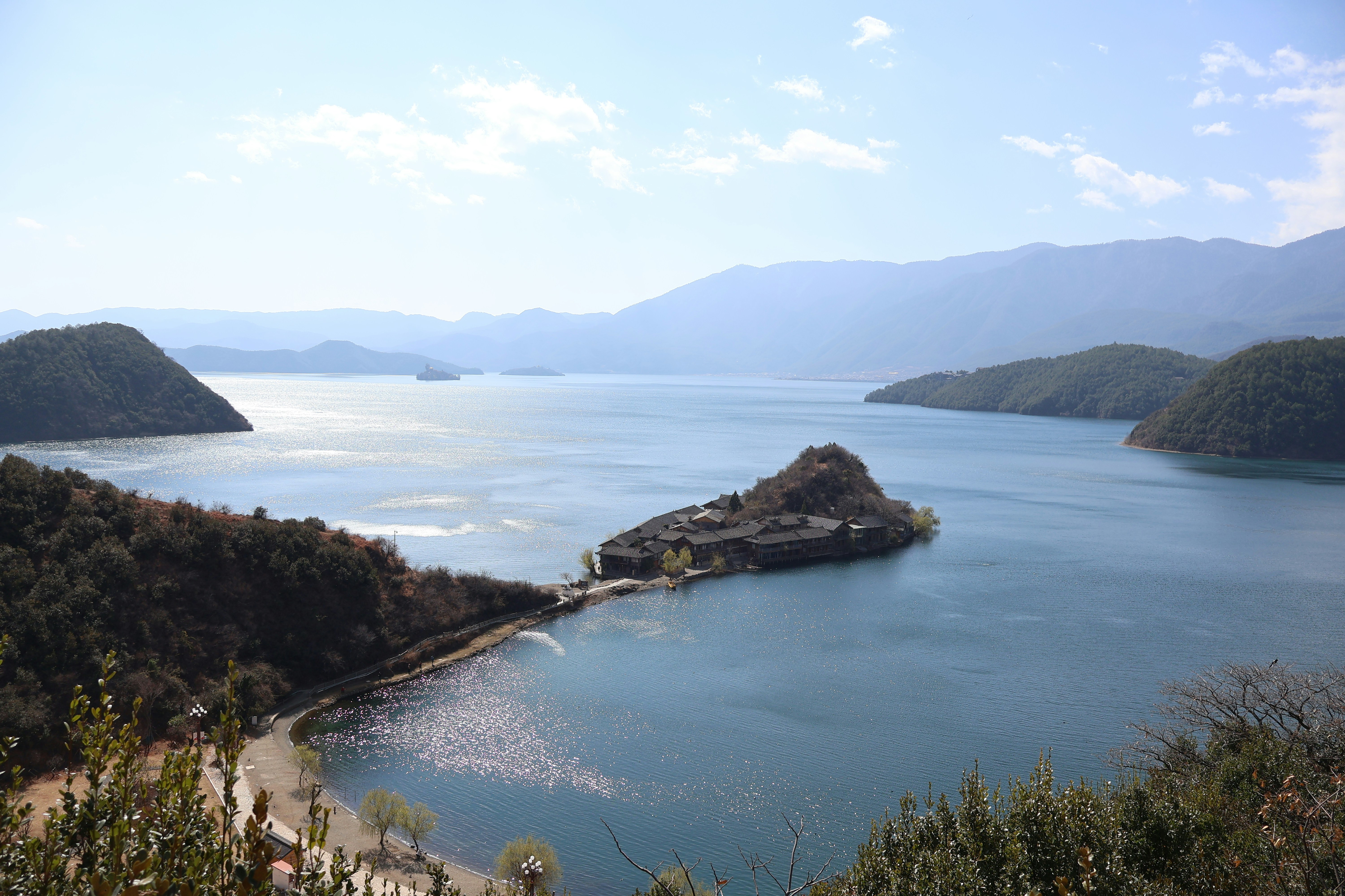 Calm lake with distant mountains and island.