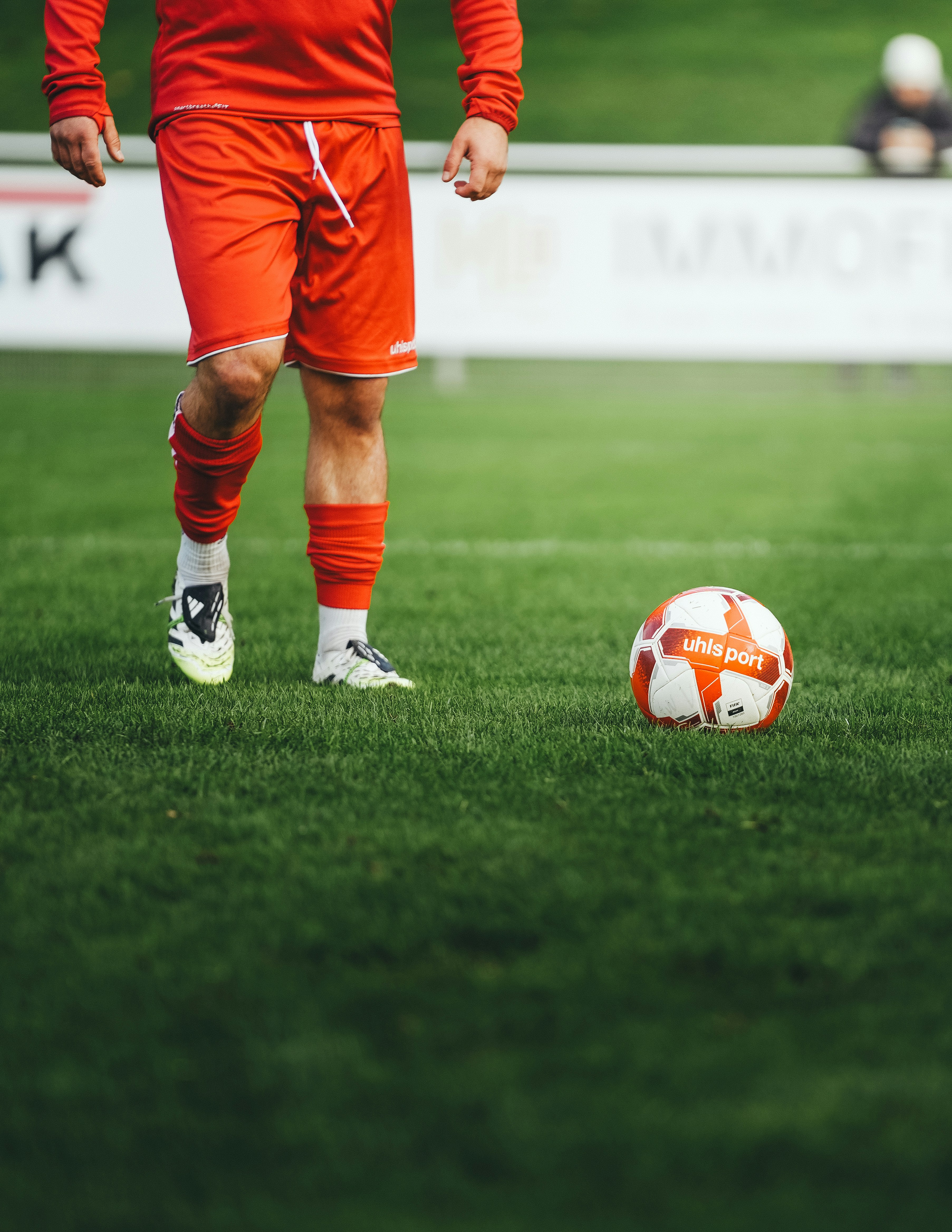 Soccer player standing near a ball on grass