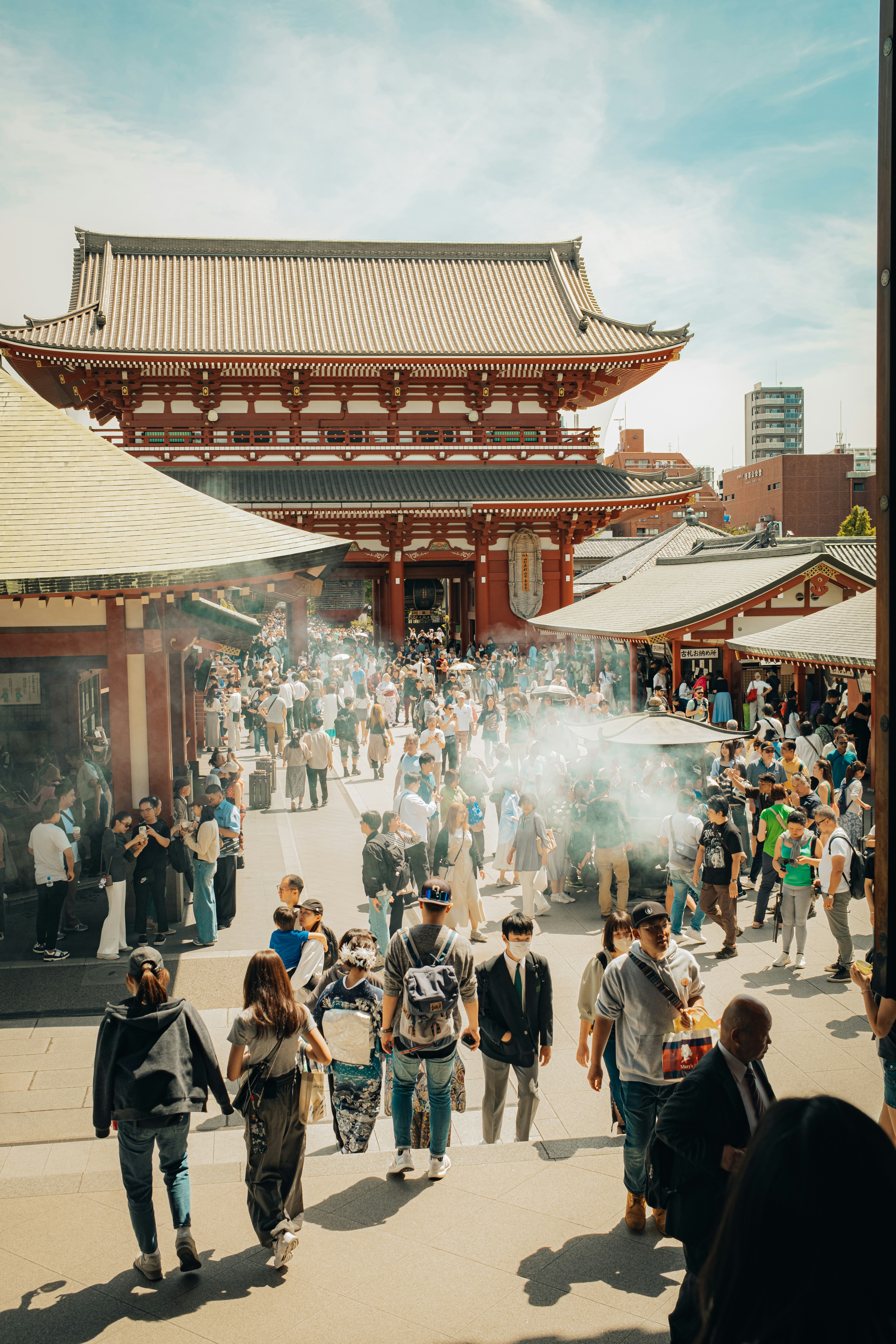 Crowded temple complex with people and incense smoke
