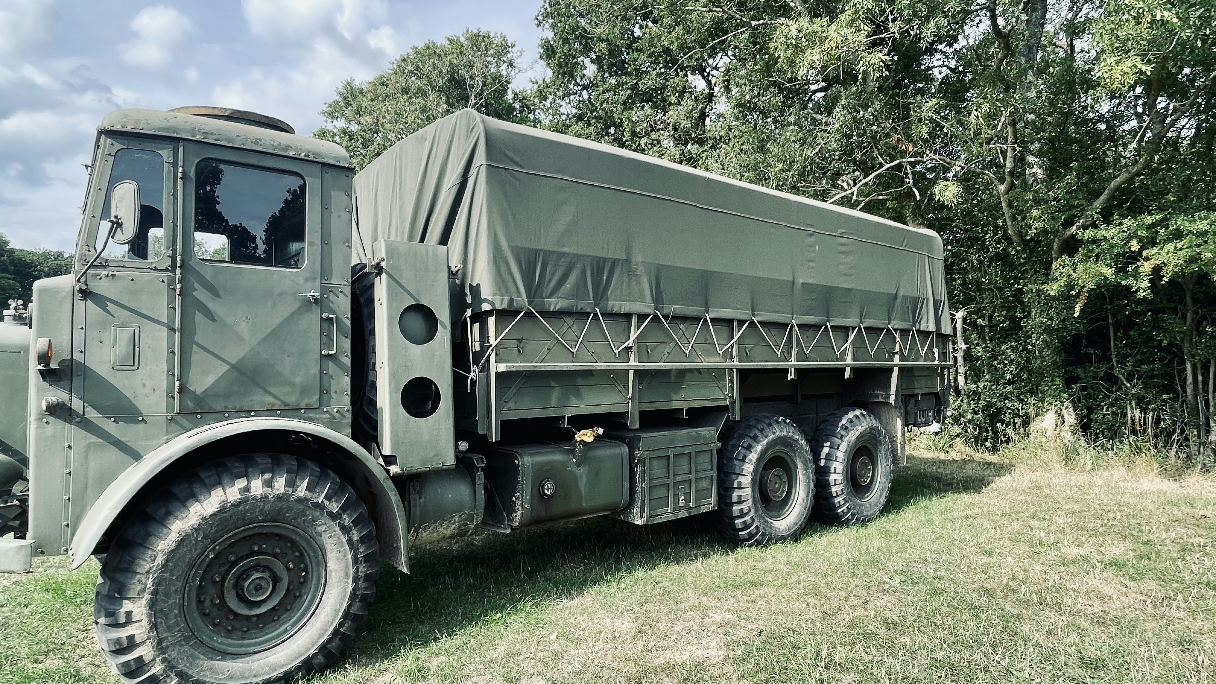 キャンバスカバー付きのビンテージオリーブグリーンの軍用トラック