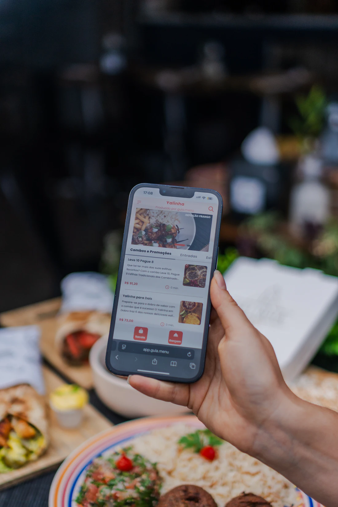 Hand holding a smartphone with a food ordering app open