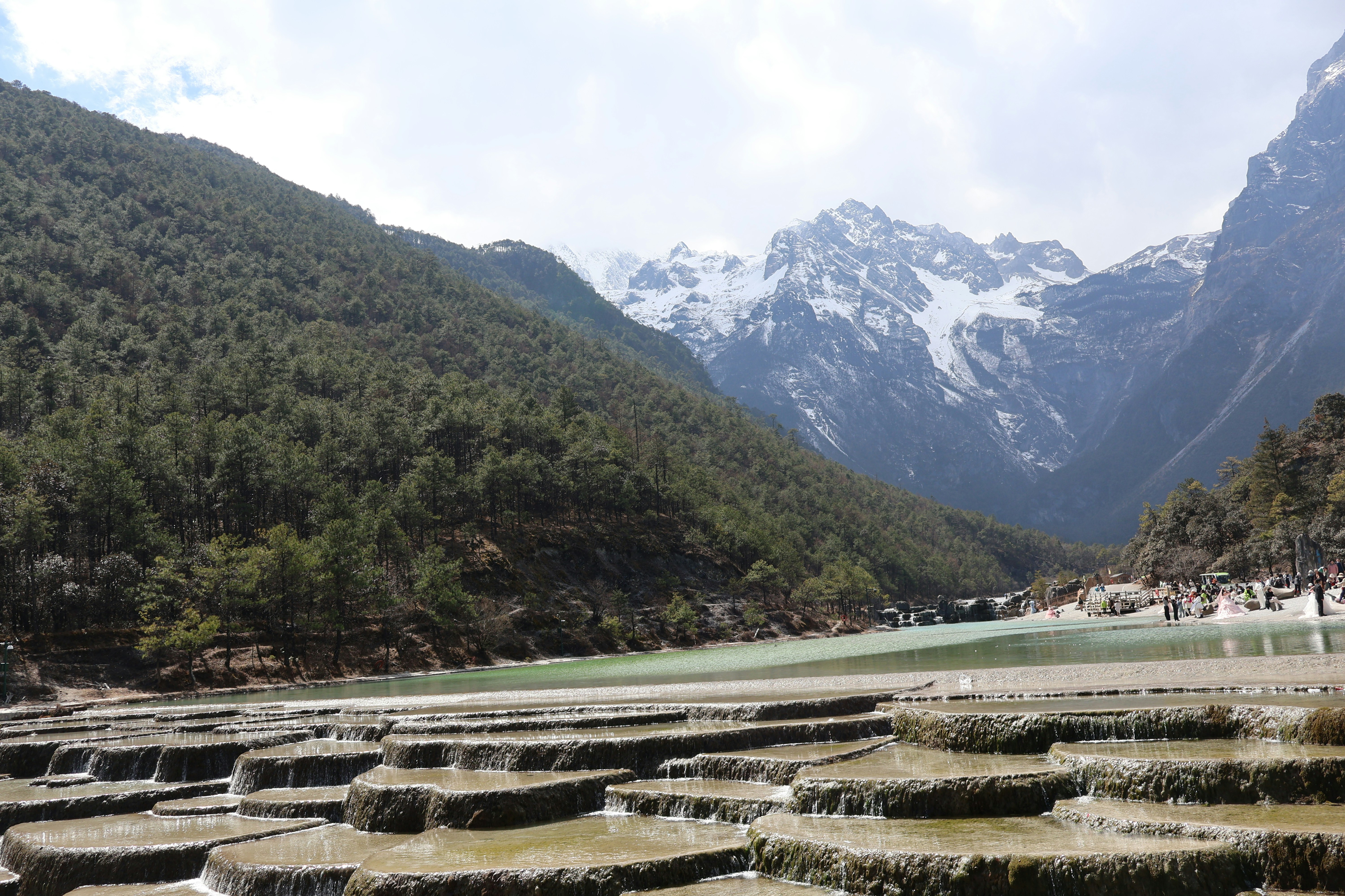 Terraced pools with snow-capped mountains in background